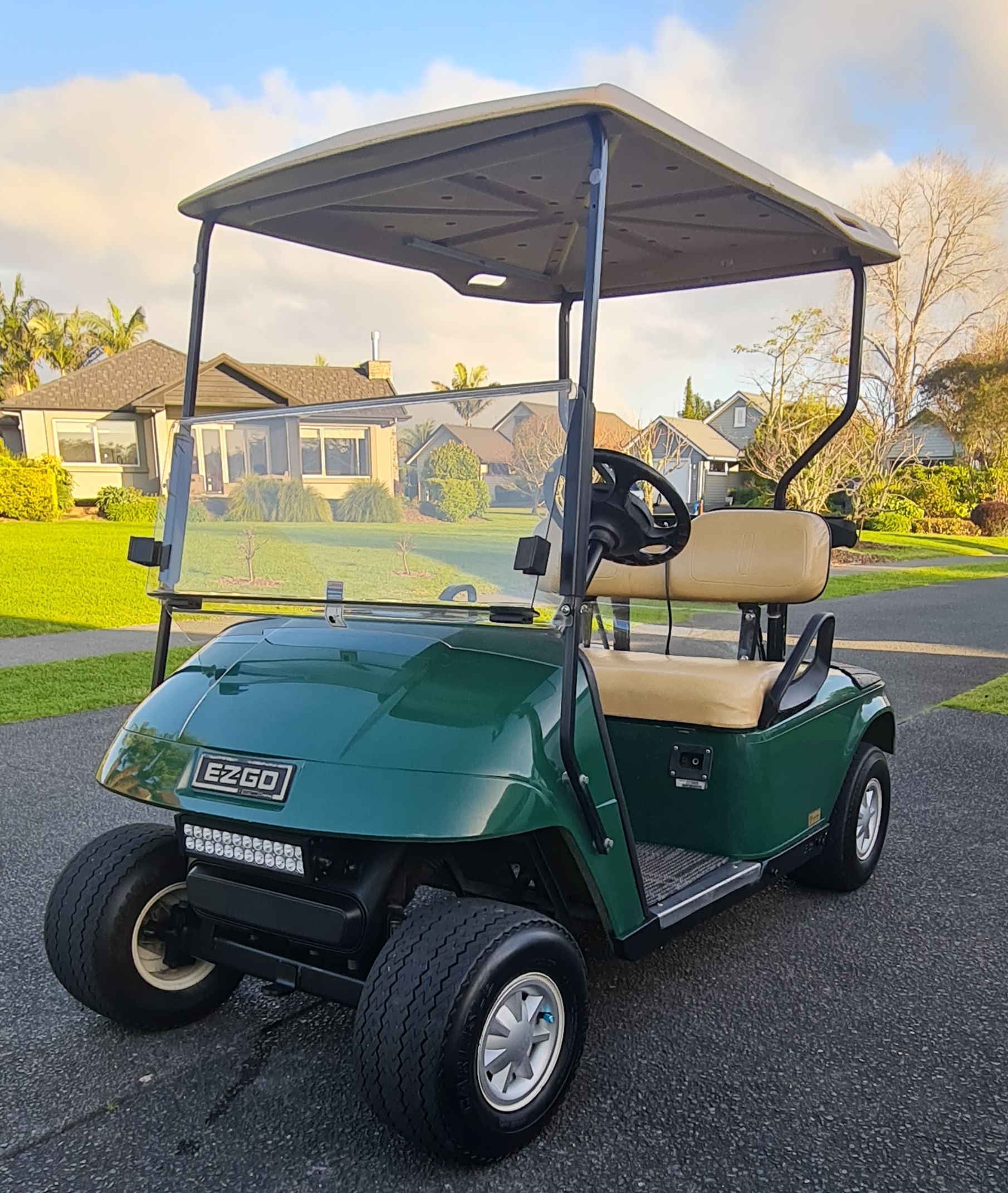 Green EZGO TXT golf cart with LED light bar and fresh service